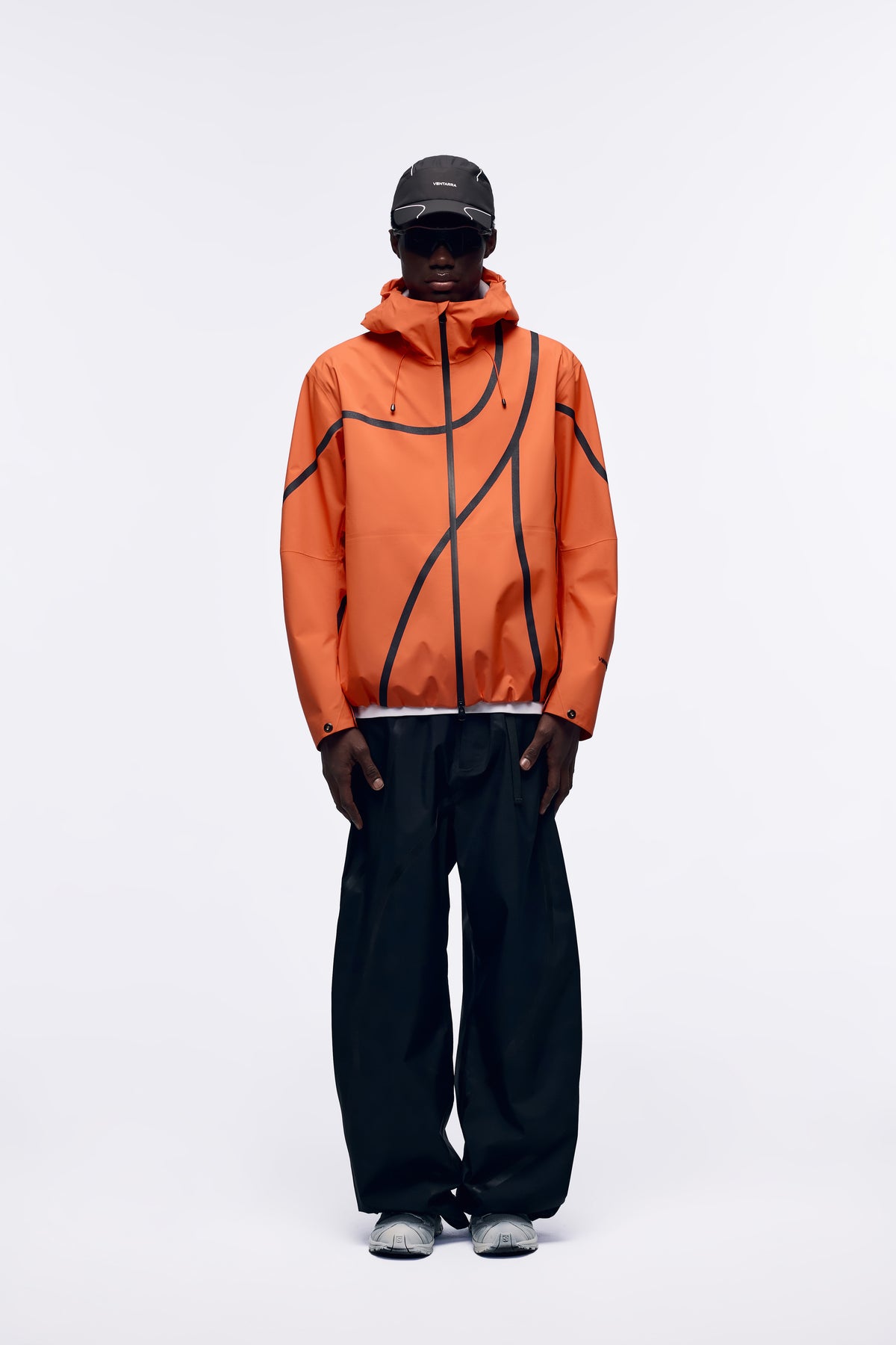 Ventarra unisex hooded shell jacket in Orange — waterproof 3-layer composite with asymmetric external tape strips and adjustable hood