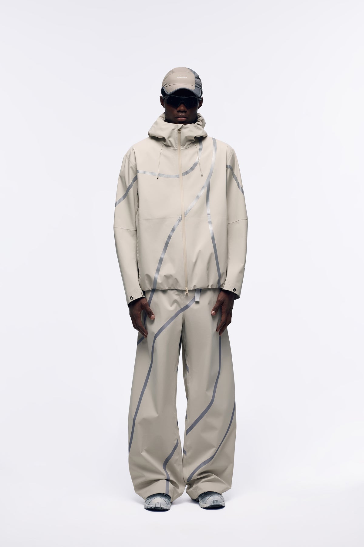 Ventarra unisex seam-taped shell pants in Light Khaki — waterproof 3-layer composite fabric with asymmetric color-block strips and curved-cut silhouette