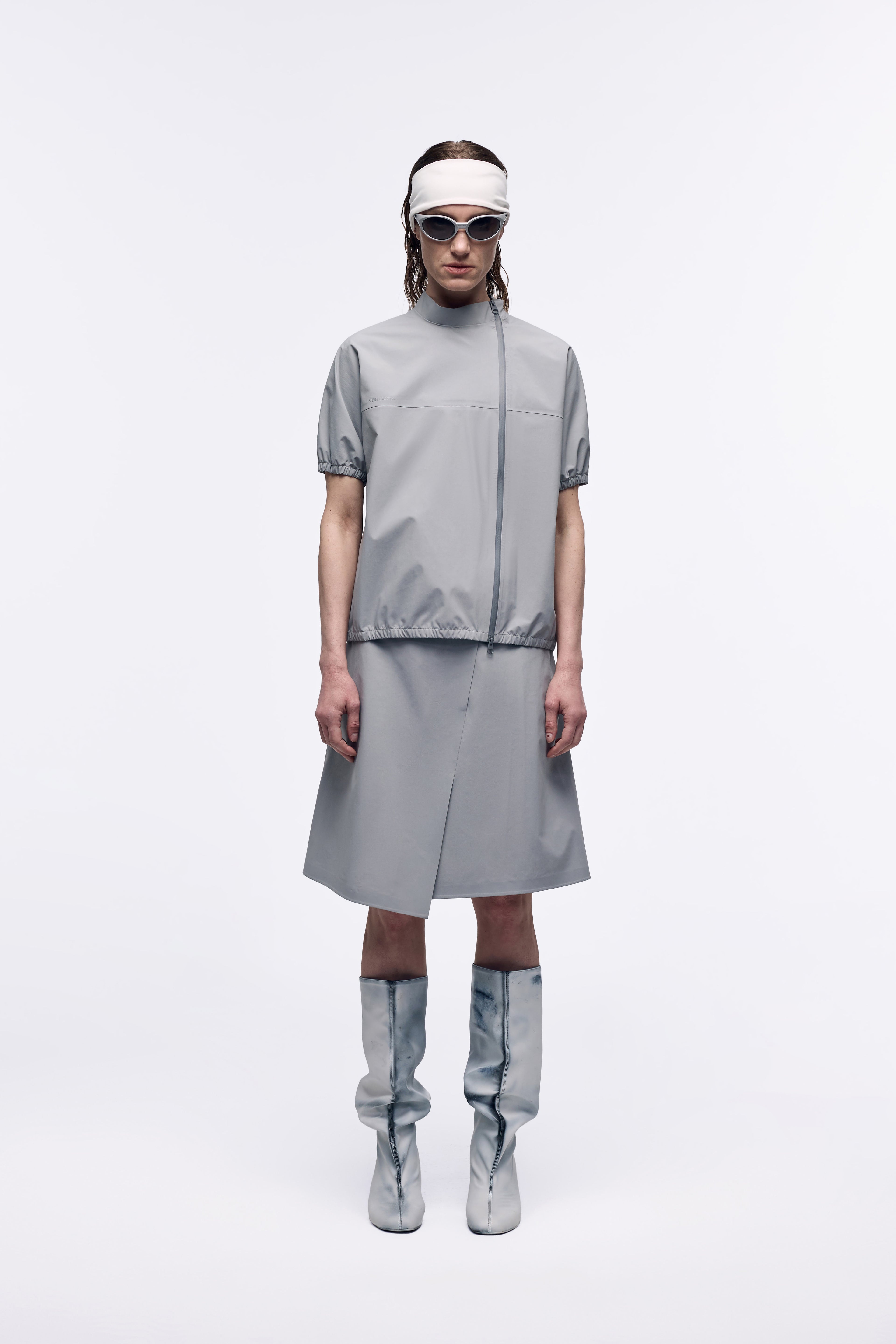 Ventarra women's bonded short-sleeve T-shirt in gray — front view, windproof laminated fabric with two-way zipper, styled with matching skirt and boots
